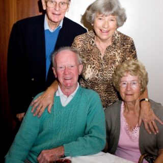 Group of four adults at a social table.