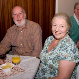 Couple seated at a social event with snacks and drinks
