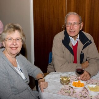 Smiling pair at a table with wine and snacks