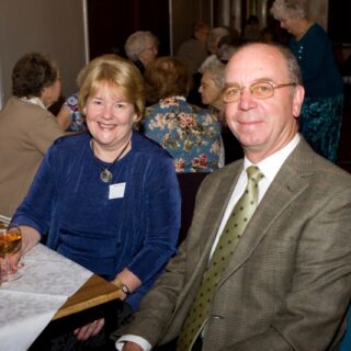 Woman and man seated at a table during a community event.
