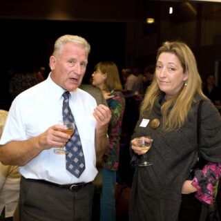 Two individuals in conversation at a community gathering.