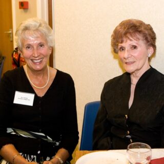 Mrs. E. Davies and another attendee seated at a table during a formal gathering.