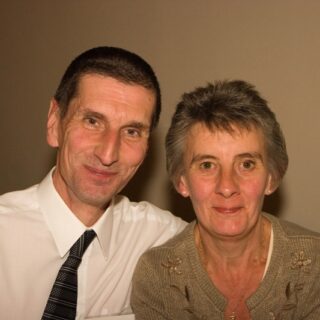 Two people seated closely together, posing for a photo.