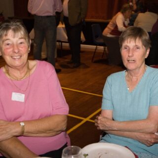 Mary Palmer and a guest seated at a table during the 35th anniversary.