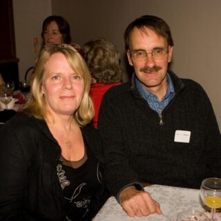 Mr. L. Smith and a guest seated at a table during the Basinga 35th anniversary.